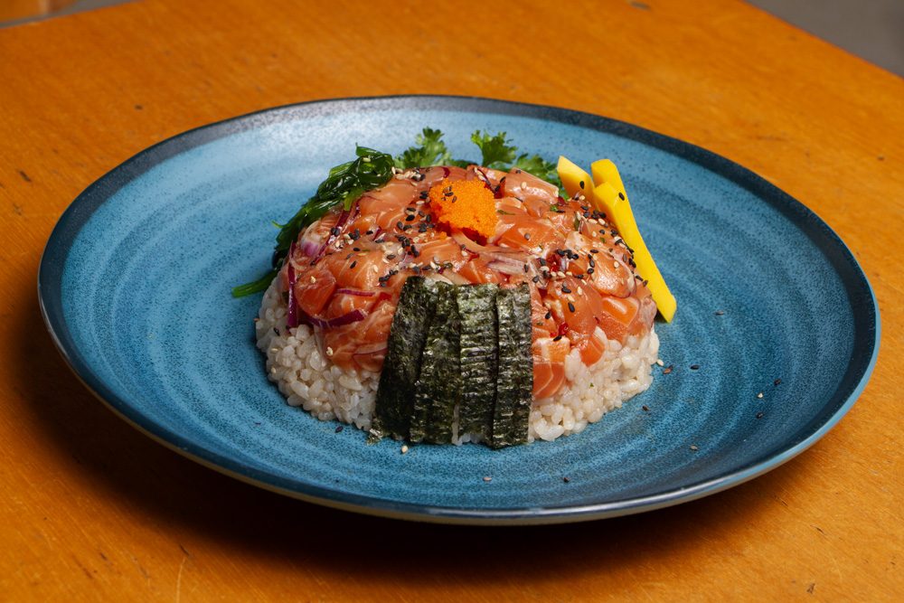 Poke de salmão em cubos sobre arroz, com cebolinha e gergelim, servido em tigela