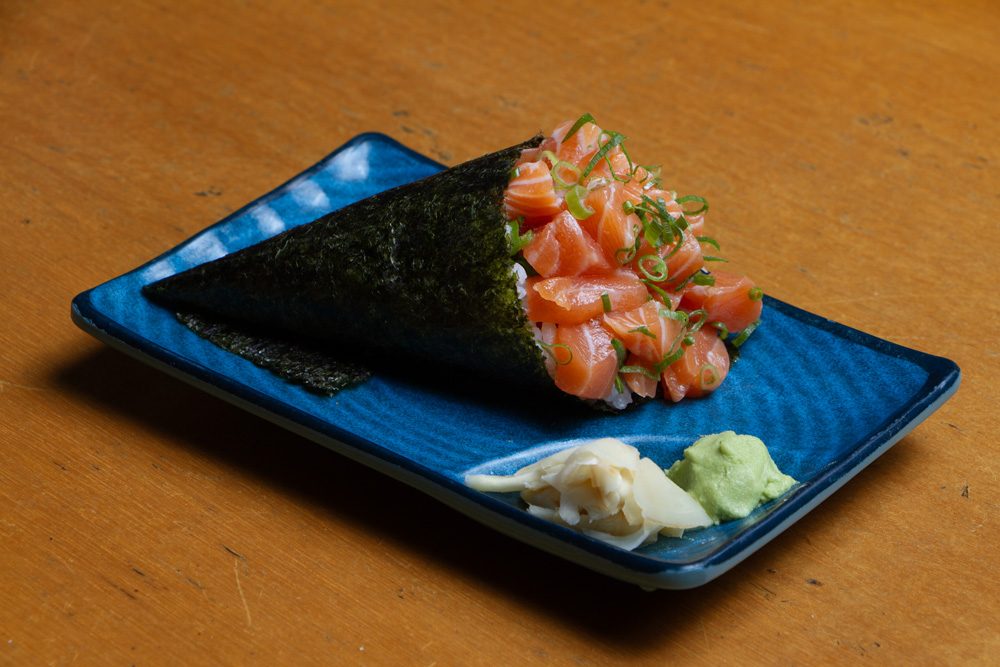 Temaki de salmão: cone de alga nori recheado com arroz e salmão cru picado